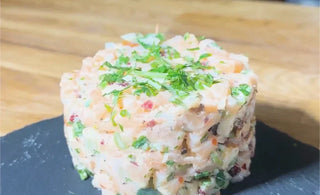 Tartare de saumon, canneberges séchées CANNE BERGE et amandes sur une pierre de présentation