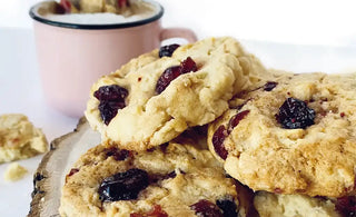 Biscuit moelleux à l'orange, chocolat noir et canneberges séchées par CANNE BERGE avec un verre de lait à côté