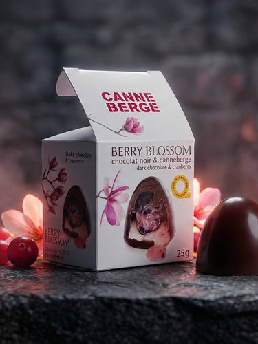 boite de berry blossom avec un berry blossom à côté déposé sur une roche avec des canneberges
