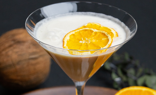 verre de amaretto coco avec deux tranches de citron dans le verre. mocktail fait avec l'amaretto sans alcool sobr