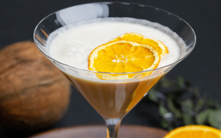 verre de amaretto coco avec deux tranches de citron dans le verre. mocktail fait avec l'amaretto sans alcool sobr