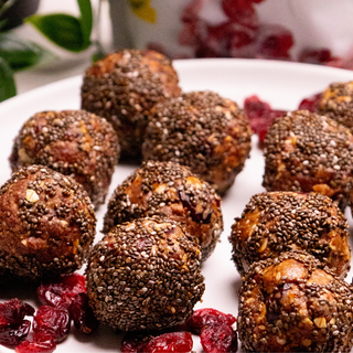 Boules d'énergie aux canneberges à l'orange déposées sur une assiette blanche