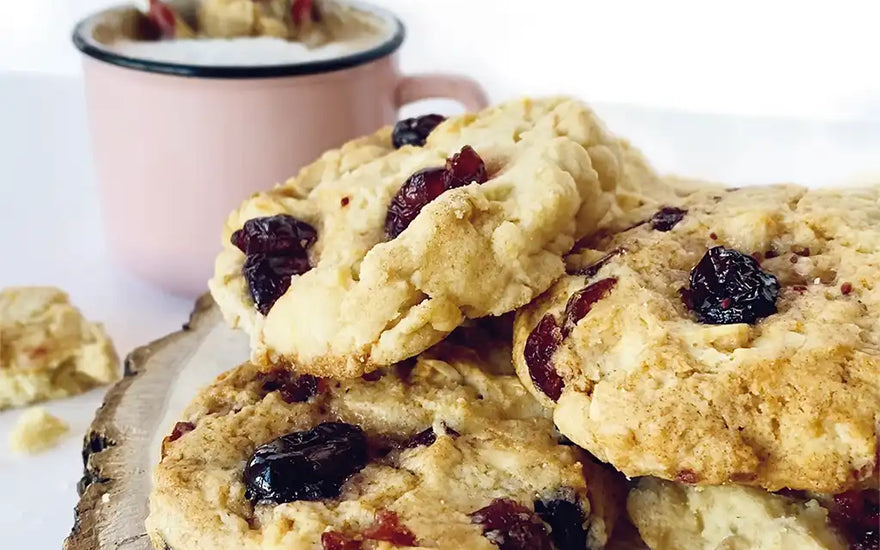 Biscuit moelleux à l'orange, chocolat noir et canneberges séchées par CANNE BERGE avec un verre de lait à côté