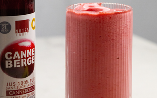 Verre de smoothie fraise, framboise et canneberge avec une bouteille de jus concentré de canneberge sans sucre par CANNE BERGE
